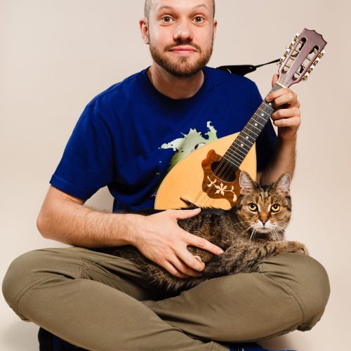 muzyk grający z mandoliną i kotem
